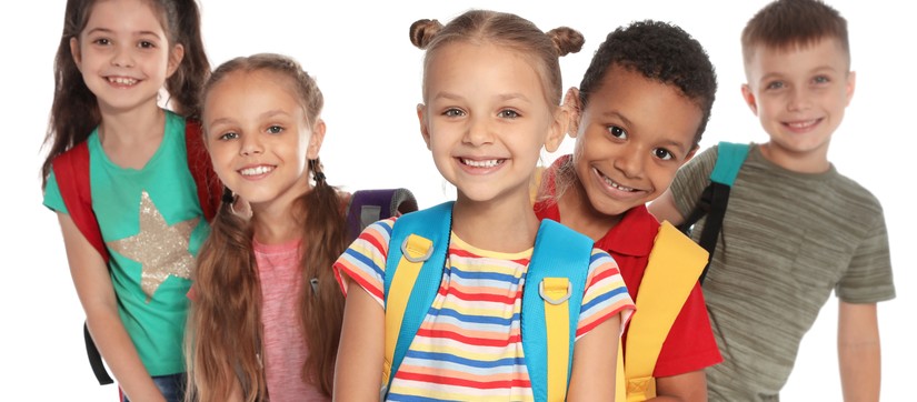 Kinder im Primarstufenalter mit Schultaschen und Rucksäcken
