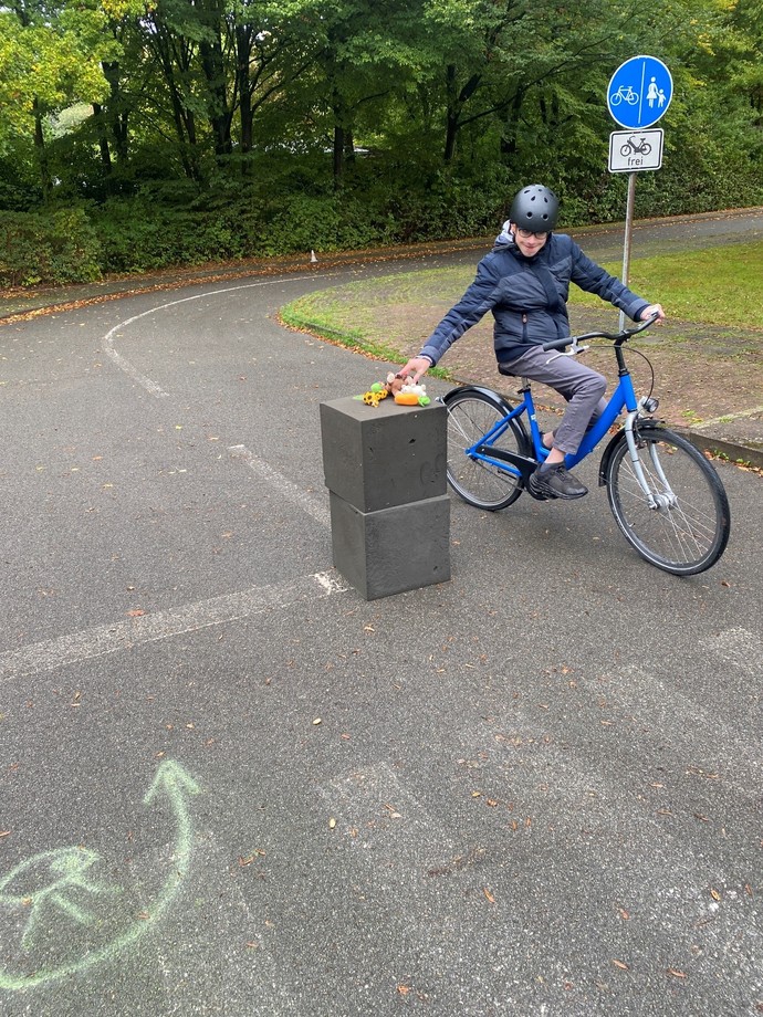 Schüler fährt einhändig auf dem Fahrrad
