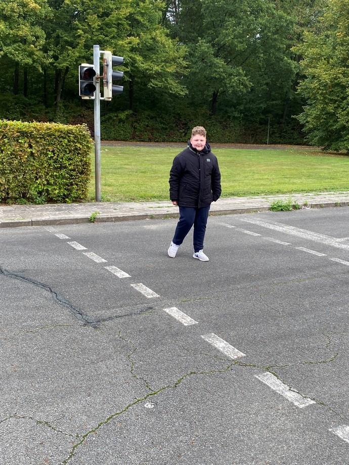 Schüler überquert die Straße an einer Ampel