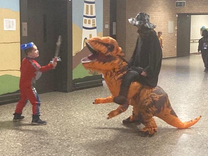 Schüler kämpft mit Dino (vergrößerte Bildansicht wird geöffnet)