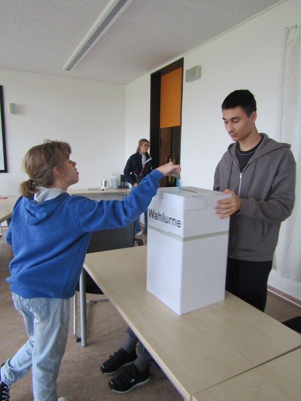 Ein Wahlschein wird eingeworfen.