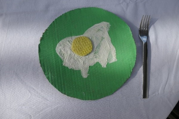 Ein gestaltetes Spiegelei auf einem grünen Teller