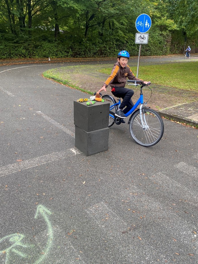 Schüler fährt einhändig Fahrrad