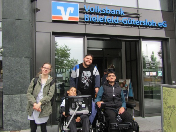 Die Gruppe vor dem Gebäude der Volksbank. Zu sehen sind Annika, Wali, Lucas, Ahmad